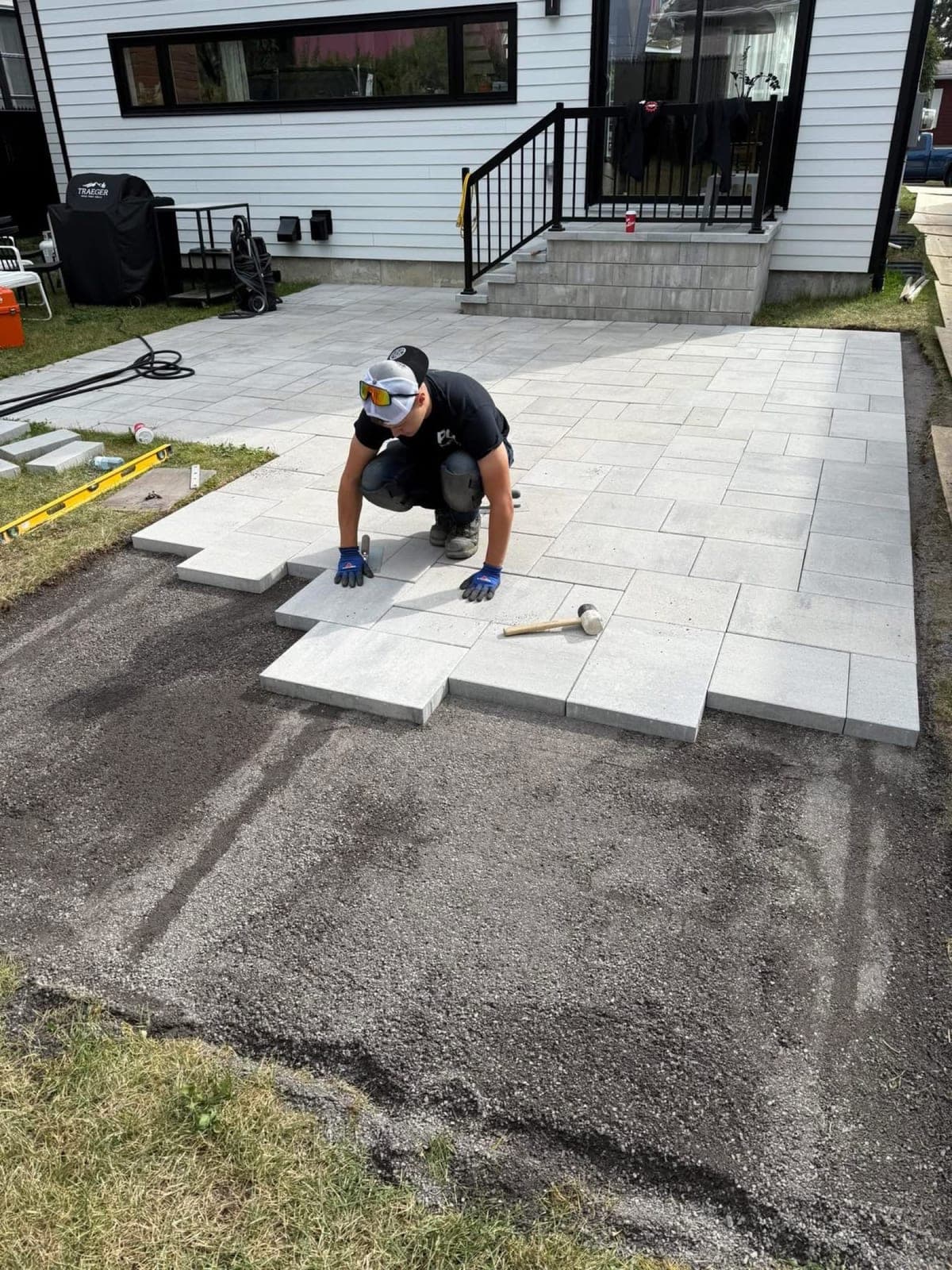 Installateur ATLA posant une dalle de patio grand format