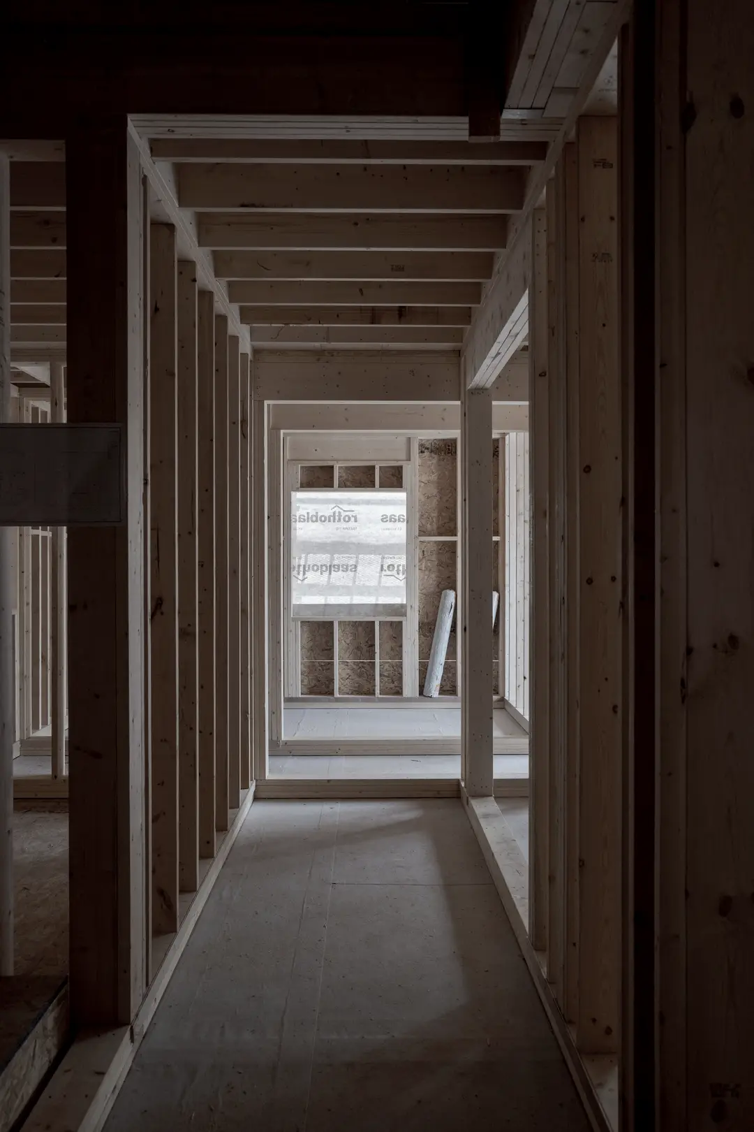 Enfilade de pièces en ossature de bois, lumière du jour au fond